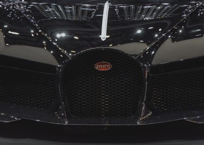 Primer plano de la parrilla frontal de un Bugatti con el logotipo característico, destacando su distinguido diseño y calidad superior.