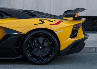 Parte trasera lateral de un vehículo Lamborghini de colores amarillo con negro.